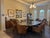 An exceptional handcrafted dining collection featuring a monumental expandable oval dining table acquired through a...