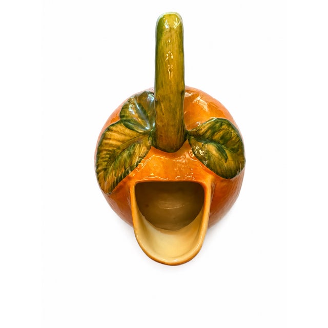 A charming vintage ceramic vessel with a wonderfully sculptural fruit-inspired form and rich, glossy orange glaze. Dating...