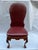 A single carved wood side chair featuring ball and claw feet and dark red leather upholstery with nailhead trim.