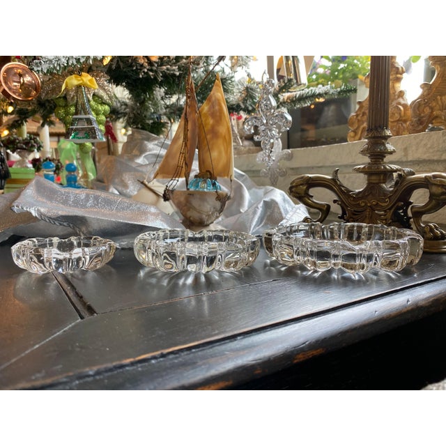 A set of three glass ashtrays. Appear as a nest when stacked.