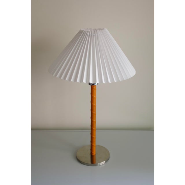 Swedish Mid-Century Table lamp with new leather wrapped around the lamp arm and a metal, possibly nickel plated, lampfot....