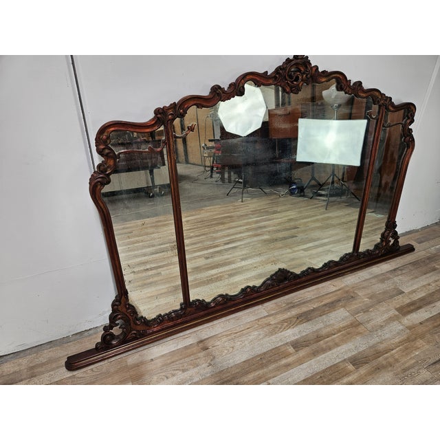 An elegant period Italian mirror, featuring a richly carved and shaped wooden frame with refined ornamental motifs of...