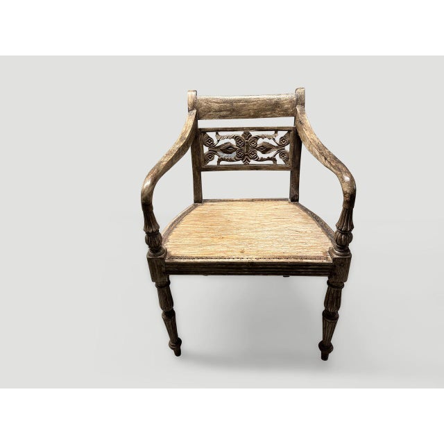 Stunning hand carved teak arm chair with beautiful patina. The front legs and arm rests are beautifully fluted and hand...