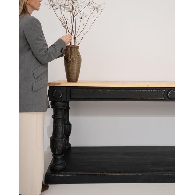 This piece presents as a table, distinguished by black painted wood, turned baluster. Dating to 20th Century and...