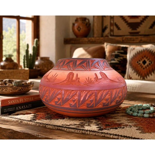 Beautiful handcrafted Native American red earth pottery vessel featuring deeply carved geometric motifs and a striking...