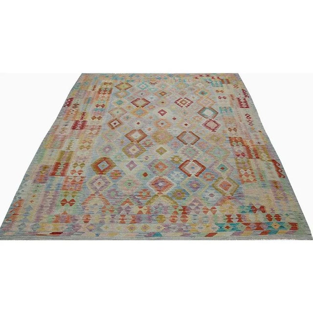This fun rug is a beautiful traditional handwoven Turkish Kilim area rug featuring a tile and geometric shape motif in a...