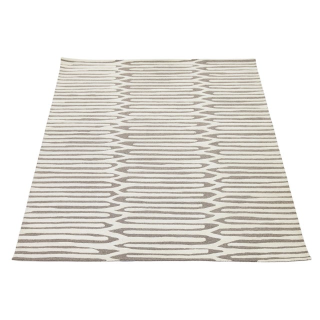 This sophisticated hand-tufted rug features a striking organic geometric pattern, blending mid-century modern aesthetics...