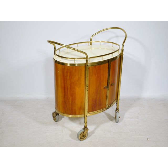 Elegant bar cart in walnut and brass, Italy, 1950s. A characteristic design of the period with a curved, semi-oval shape...