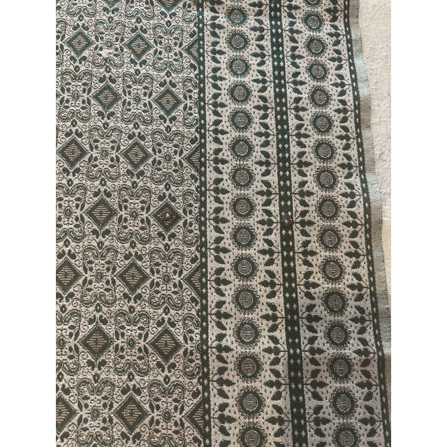 The fabric was never used. It is an all over design beautiful green color with with fringes . You can use it as a table...