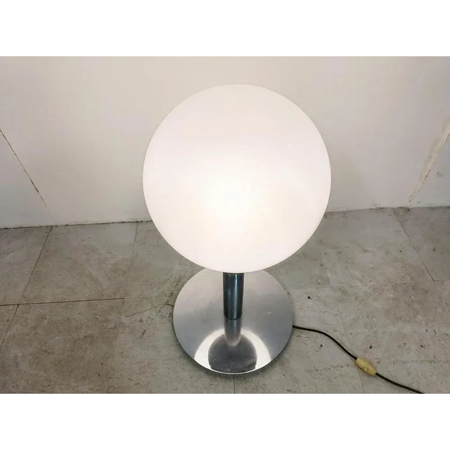 Mid century table lamp with a chrome base and a glass globe shade. Cool vintage table lamp which emits a nice dimmed...