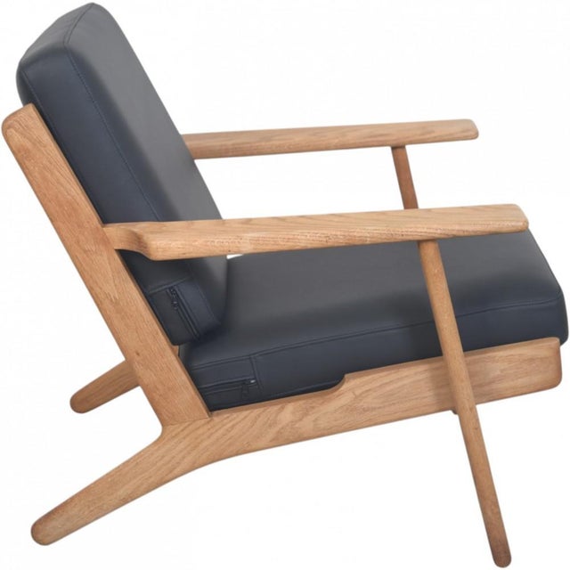 Hans Wegner GE290 lounge chair with a frame of oak and new foam cushions upholstered with black semi anilin leather. The...