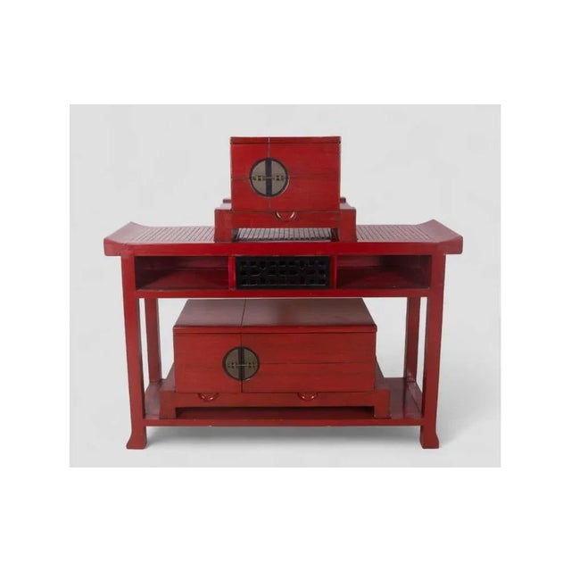 Captivating vintage oriental sideboard in red lacquered wood, defined by clean geometric lines and refined craftsmanship....