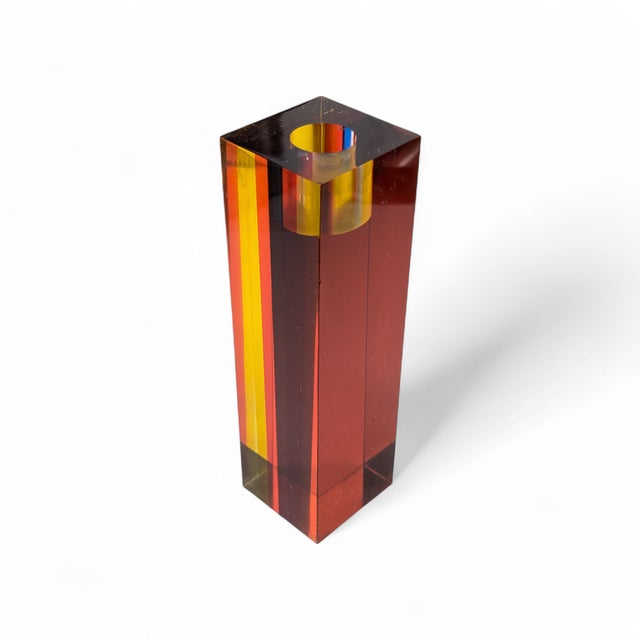 A candlestick holder by Richard Soong. Made from laminated lucite that change colors depending on which direction you view...