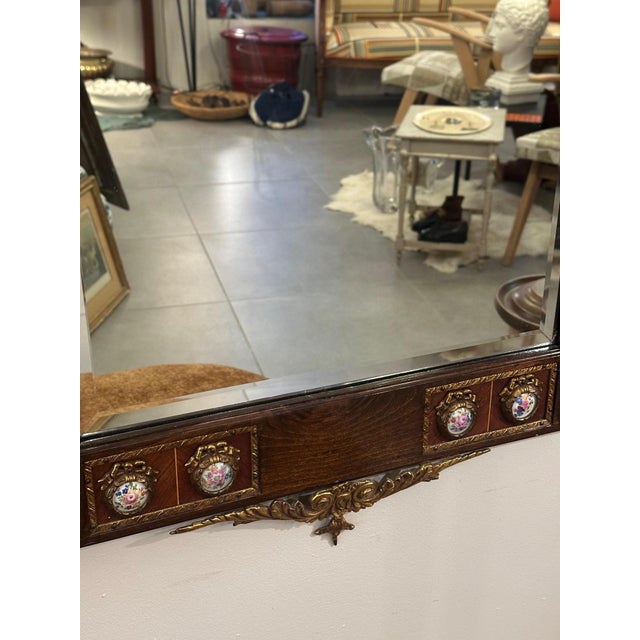 A superb 19th-century mirror, featuring a richly carved wooden frame adorned with painted porcelain medallions, delicately...