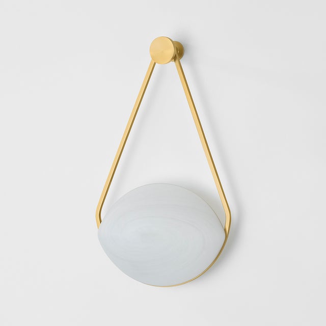 Inspired by the elegance of a drop earring, the ethereal Blaina sconce features a soft oval-shaped shade supported by an...