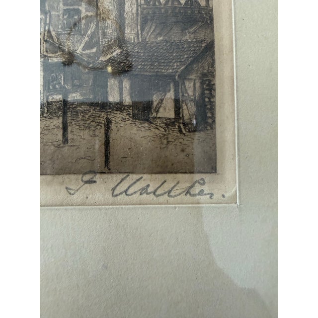 The image shows an antique black-and-white architectural etching in a dark wood frame, depicting a traditional European...