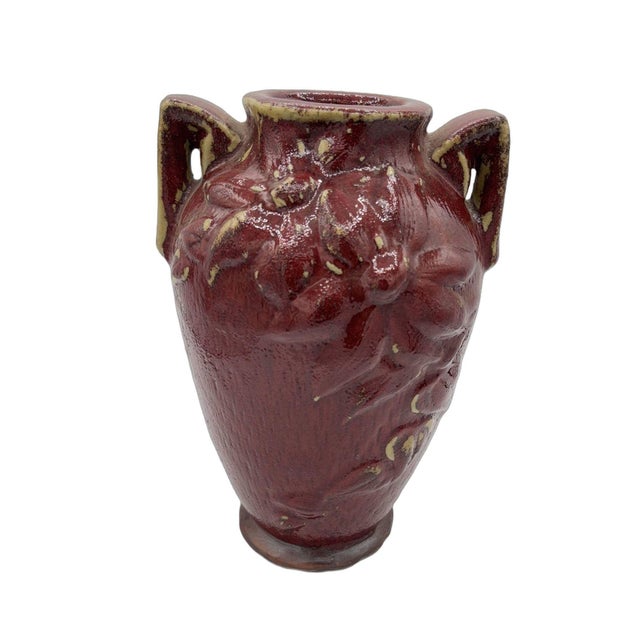 Striking and richly textured, this vintage art pottery vase features a deep oxblood red glaze accented with warm golden...