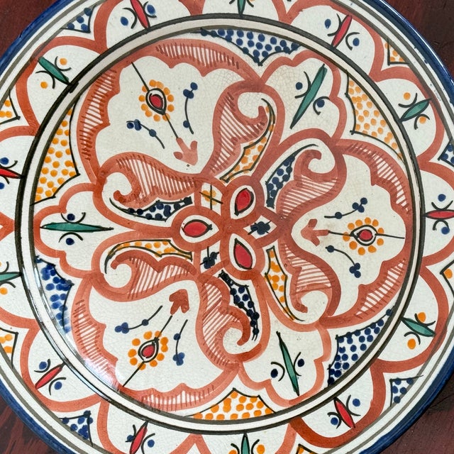 Round hand painted shallow ceramic bowl from Safi, Morocco. The cream crackle glaze ground is painted in terracotta red,...