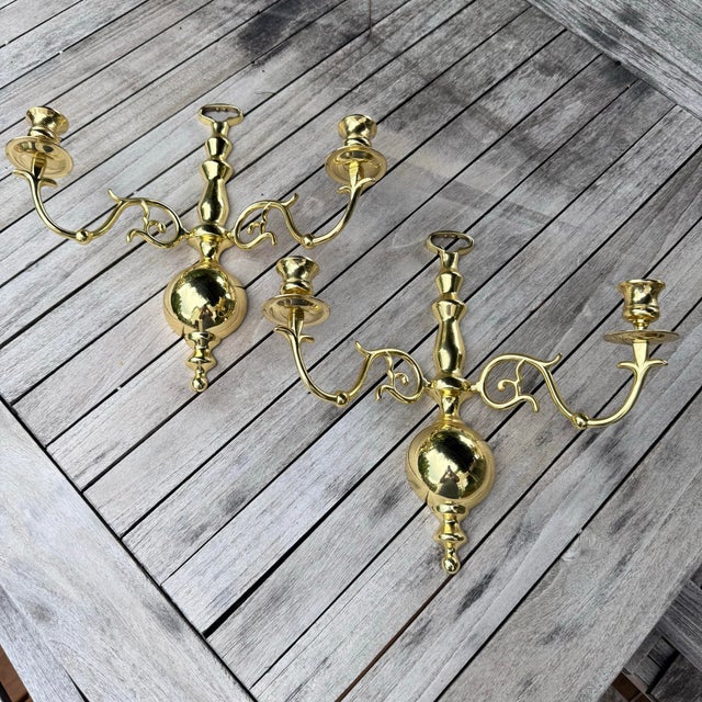 A classic pair of solid brass wall sconces with elegant scroll arms and a timeless Colonial Revival silhouette. Their...
