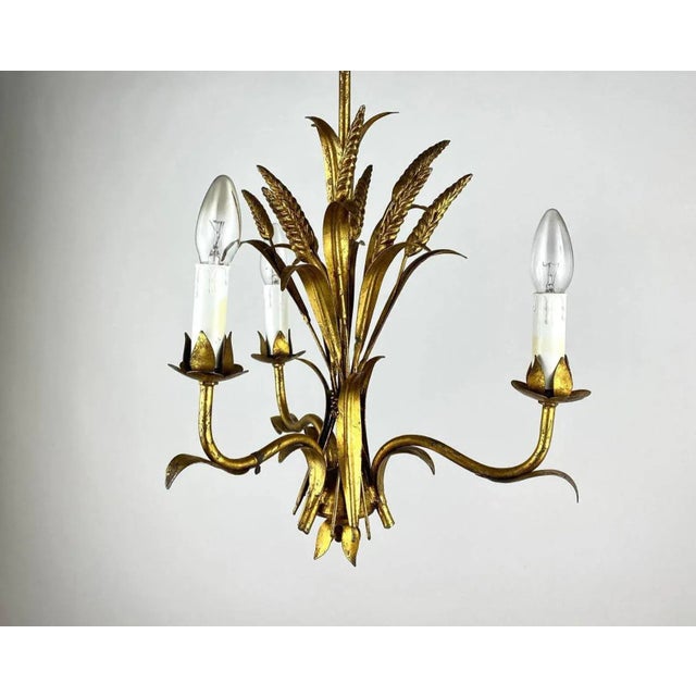 Gilded metal chandelier decorated with ears of wheat. A Hollywood Regency “Coco Chanel“ style sheaf of wheat three-light...