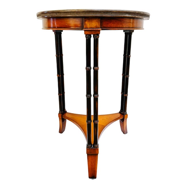 A beautifully crafted Neoclassical style accent table featuring a round mahogany top with a sunburst (starburst) veneer...