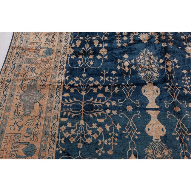 An Indian rug, the dark spacious green field with a luxurious garden design of flowering shrubs and palmettes within a...