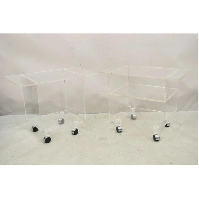 Vintage Clear Lucite Acrylic Mid Century Modern Rolling Side Tables - a Pair. Item features a slight variation in style...