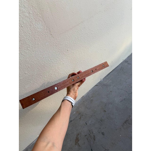 Minimalist Danish Mid Century Modern wall rack crafted from solid teak with original brass hooks. This compact piece...