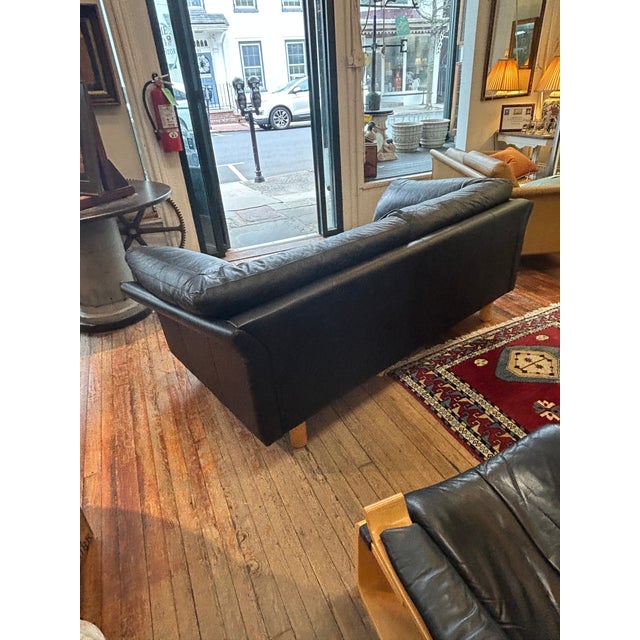 Super luxurious Danish midcentury modern black leather down filled sofa by Stouby having cylindrical beech legs. Back side...
