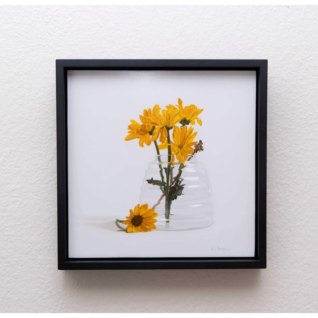 Blooming Days II features a vibrant arrangement of yellow flowers in a clear glass jar, capturing the essence of a sunlit...