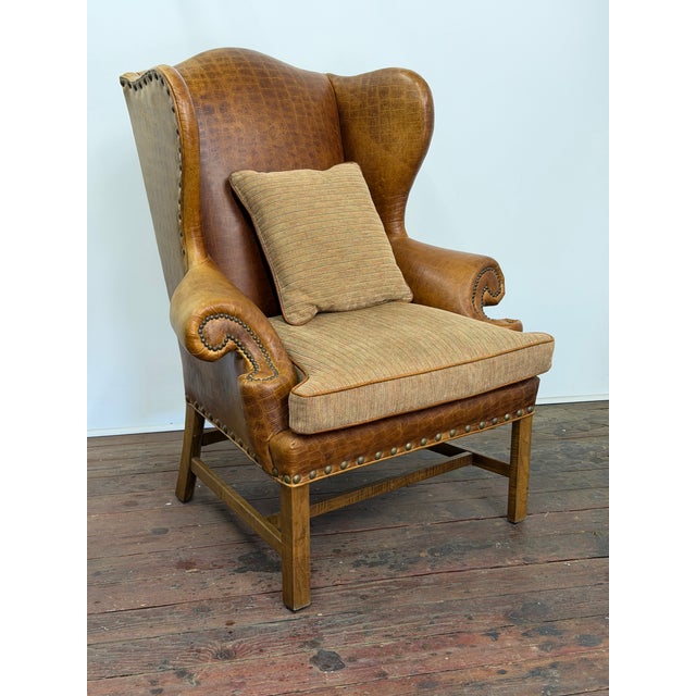 Embossed crocodile cognac leather wingback chair by Davis & Shaw. The chair features a large brass tack edging, multi-...