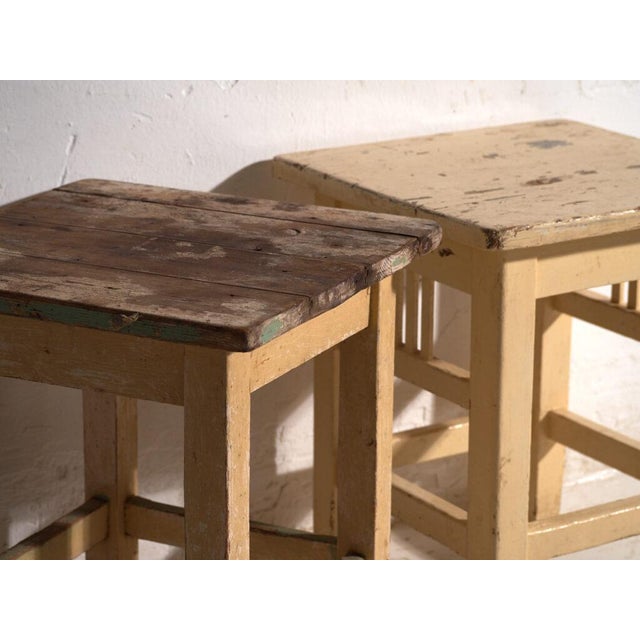 A pair of antique bedside tables in pine wood, with a square top and four tapered legs tied by box stretchers. They...