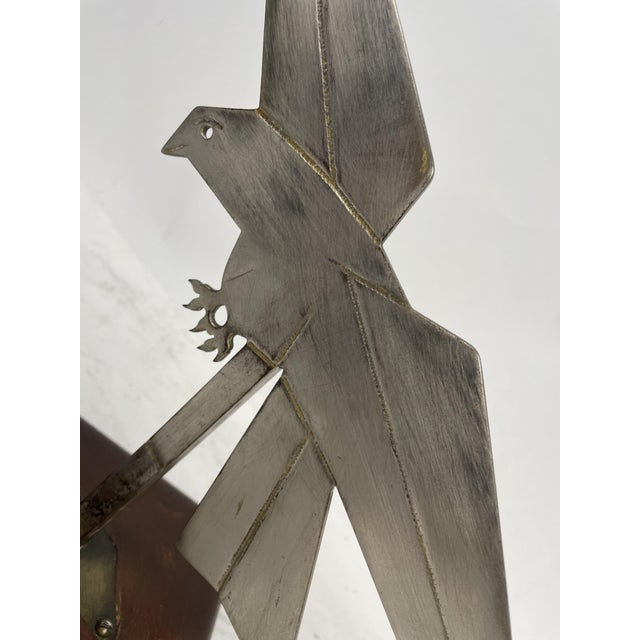 Beautiful ornament made of metal with wooden base depicting the silhouette of a falcon. Excellent furnishing object