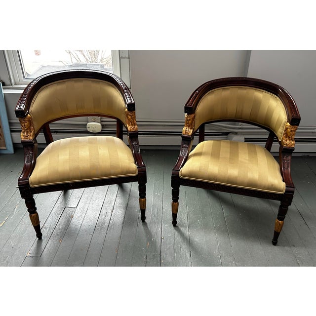 Beautiful pair of art nouveau, Egyptian revival style comfortable statement chairs. Features carved mahogany with an...