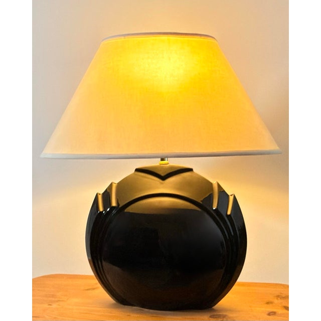 Vintage sculptural table lamp featuring a substantial high-gloss black ceramic body with a rounded central form, stepped...