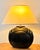 Vintage sculptural table lamp featuring a substantial high-gloss black ceramic body with a rounded central form, stepped...