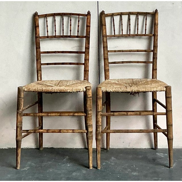 Presenting a captivating pair of Vintage French Country Chiavari Chairs, masterfully crafted with an authentic rush seat...