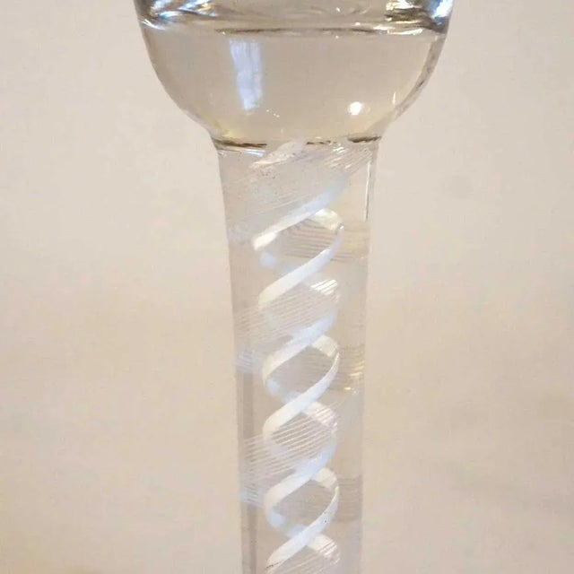 Found in Scandinavia, this antique, 18th century twist stem glass displays a tall funnel bowl, on a double series white...