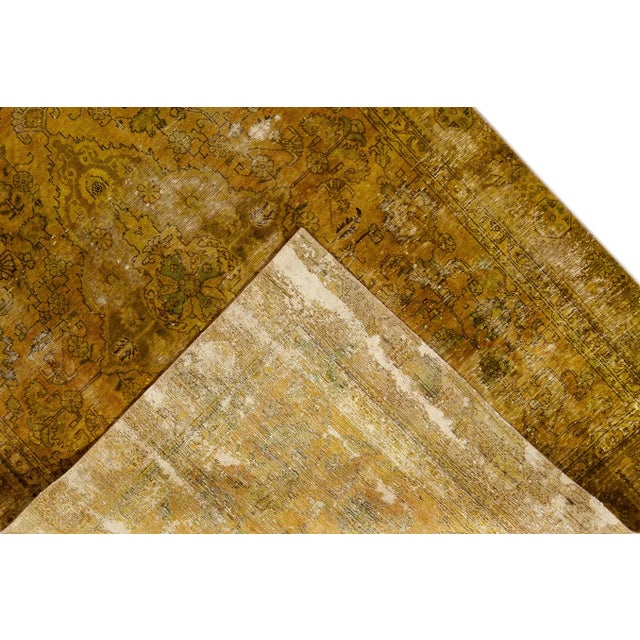 Beautiful hand-knotted vintage wool rug with a goldenrod field. This distressed rug has brown and blue accents featuring...