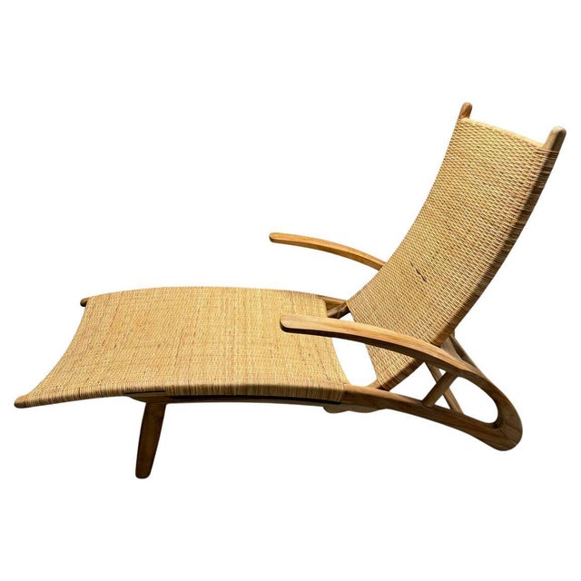 Reclaimed teak wood frame with curved dramatic arms. Hand woven grass is wrapped around the seat and back rest. This...