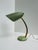 A 1950s table lamp with a slotted metal shade in its original pistachio green. The flexible brass gooseneck and brass...