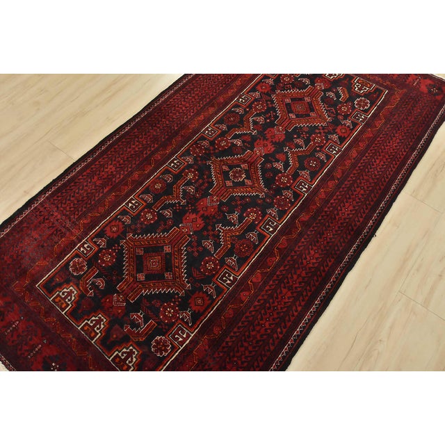 An authentic vintage tribal Baloch rug hand-knotted with fine wool and natural dyes. This nomadic carpet features...