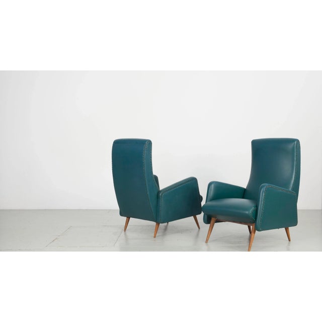 This pair of Italian armchairs from 1945 was made in the Manufatura Italiana. They are upholstered in petrol-colored faux...