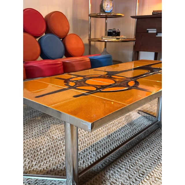 A vintage ceramic tile coffee table designed by Adri Belgique, circa 1960s. Featuring an orange glaze with an abstract...