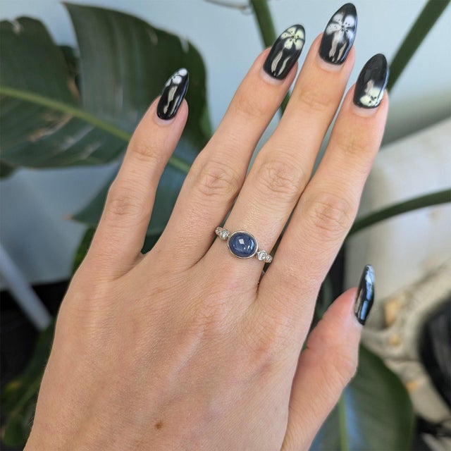 A 2.63-carat blue star sapphire displays a soft six-rayed star across its domed cabochon, set in solid 14K white gold with...