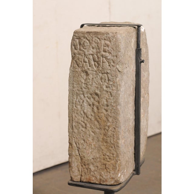 A Spanish architectural stone fragment, on custom iron stand, from the 19th century (or possibly earlier). This antique...