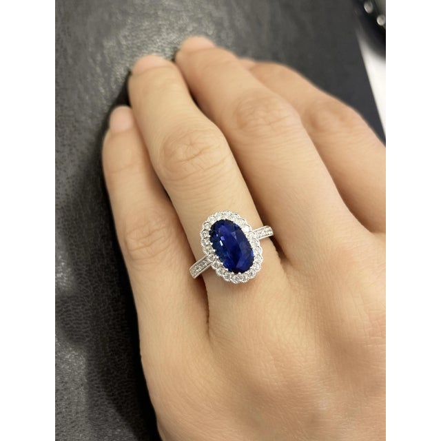 This vintage, retro, Art Deco-style ring features a GIA Certified 2.38-carat oval cut blue sapphire of Cambodian origin...