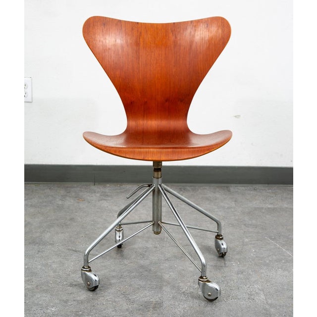 Authentic Arne Jacobsen Danish teak adjustable-height swivel desk chair, a true mid-century modern collectible. Features...
