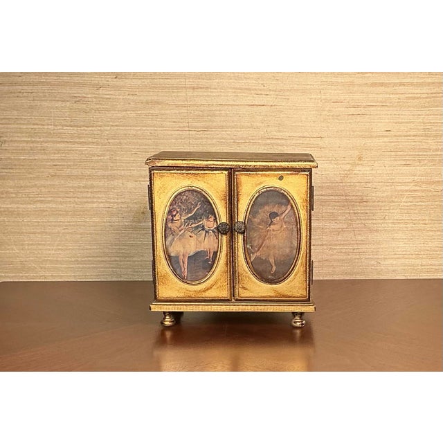 Mid Century vintage gold-gilt wooden musical jewelry chest designed in a Victorian/French Revival. Features embossed...