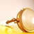 A pair of adjustable brass wall sconces with circular diffusers made of satin-finished pressed glass featuring a radial...